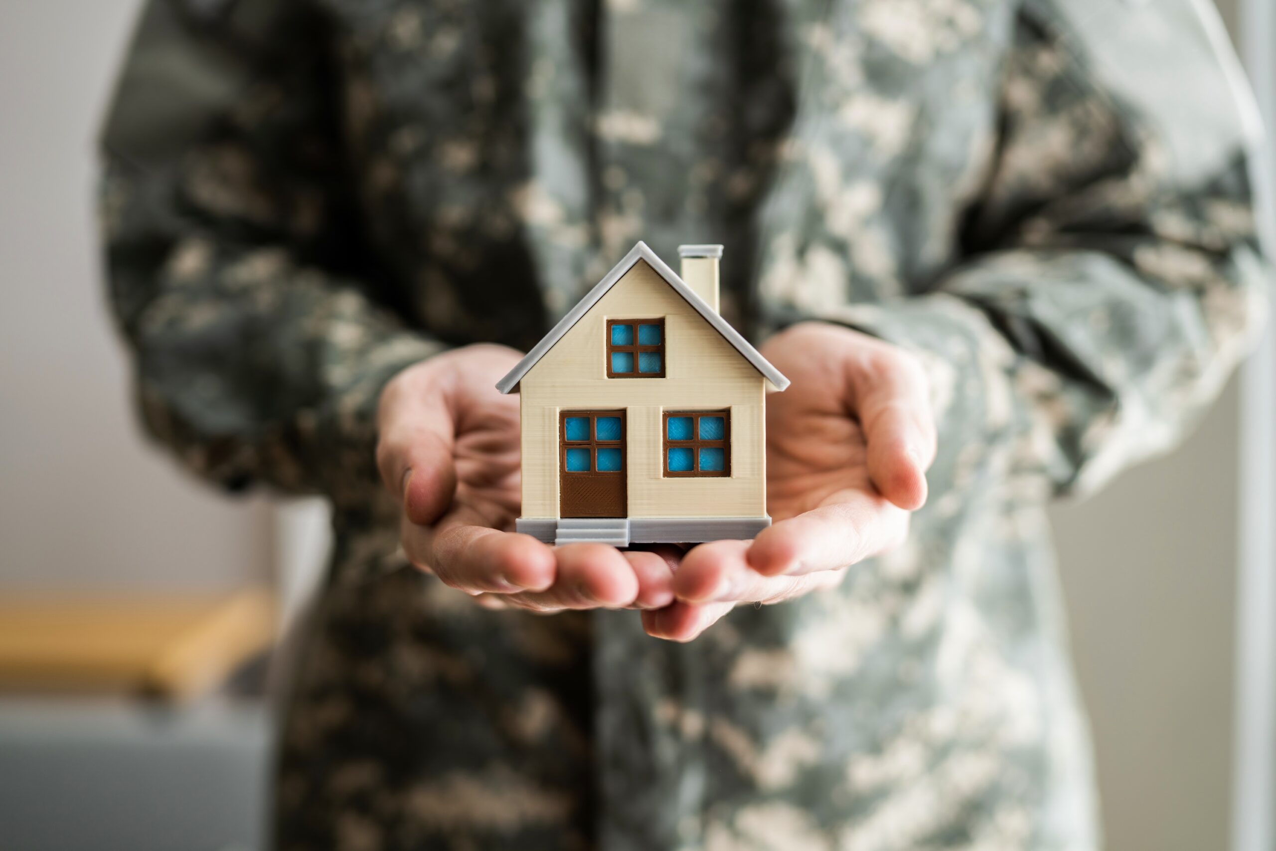 Military Army man in uniform holding new house