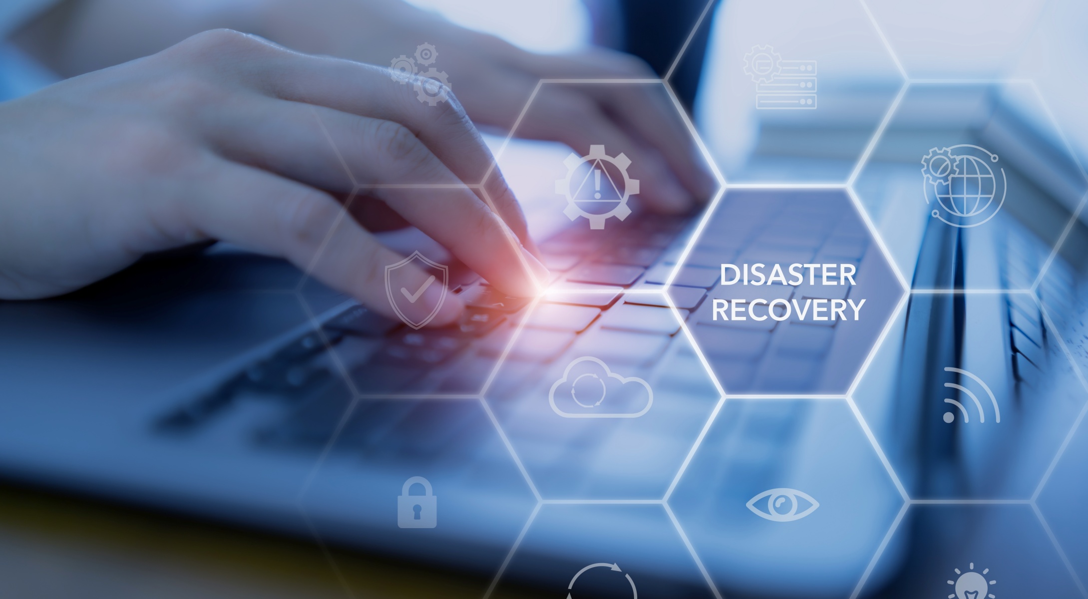 Worker using laptop to research Disaster Recover needs.