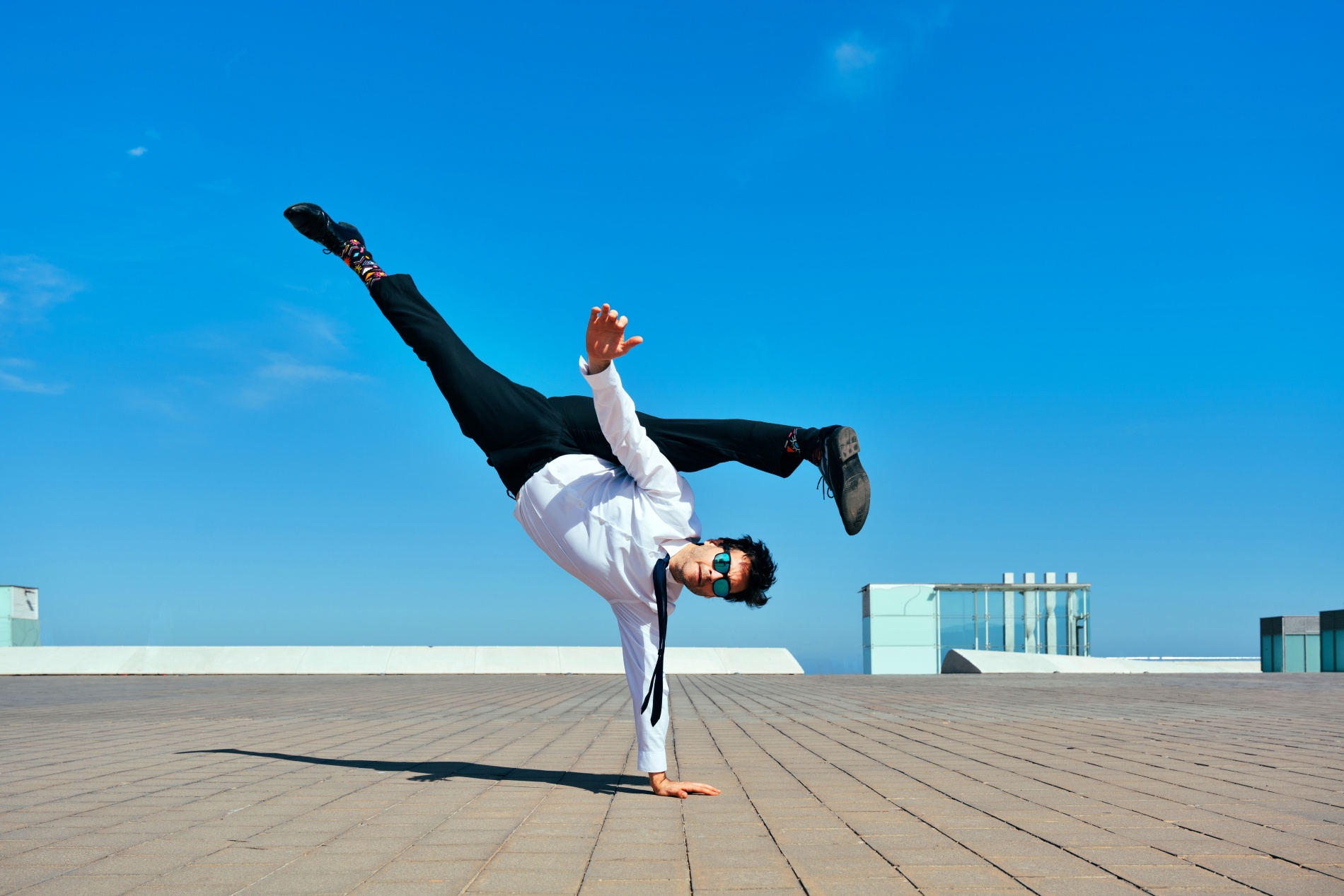 Happy and handsome adult businessman wearing an elegant suit doing acrobatic trick moves