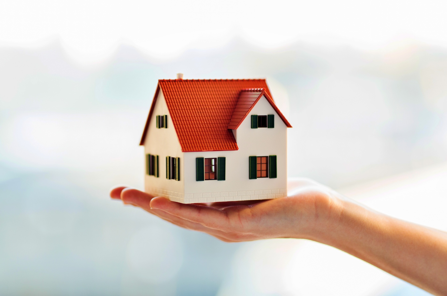 Hand holding miniature model home